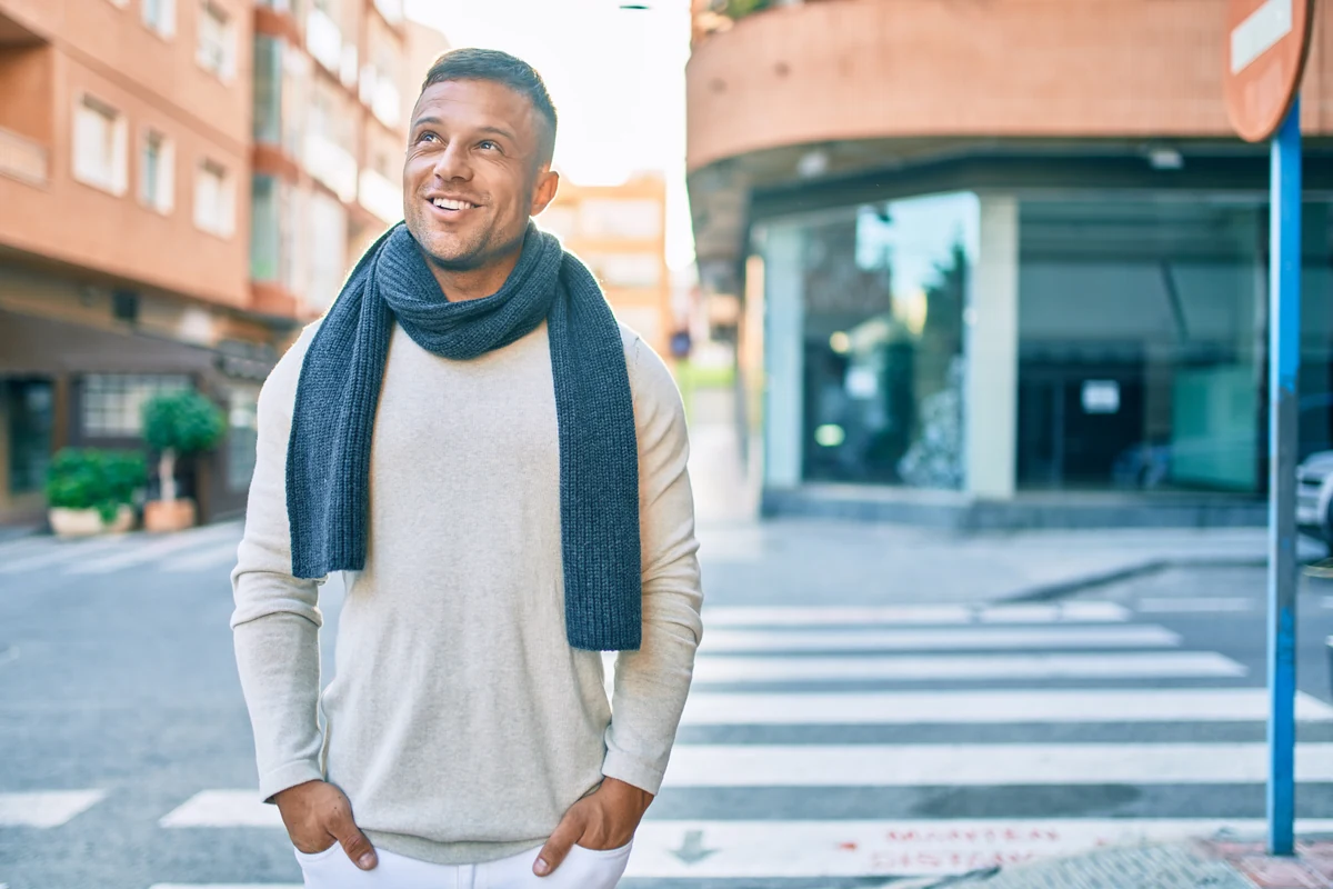 Smiling man wearing a scarf outdoors